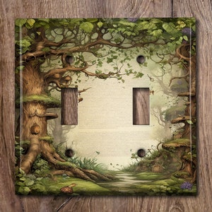 May include: A decorative light switch cover featuring a whimsical forest scene with large trees, a winding path, and small dwellings. The cover has two switch openings and is surrounded by a green and brown border.