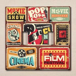 May include: A light switch cover with a collage of vintage movie posters. The posters feature images of film projectors, popcorn, and the words "Movie Show", "Cinema", "Movie Marathon", "Open Air Cinema", "International Film Festival", and "Tickets Here".