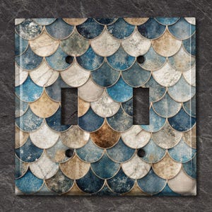May include: A double light switch cover featuring a blue, brown and white fish scale pattern.