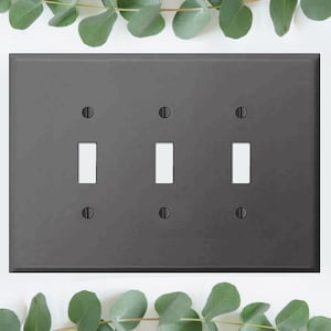 May include: A dark grey wall plate with three toggle switch openings. The plate has a matte finish and is designed to cover electrical outlets and switches.