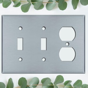 May include: A brushed nickel wall plate with two toggle switch cutouts and a single outlet cutout.