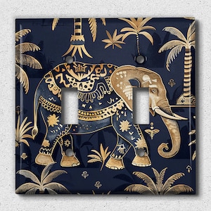 May include: A decorative light switch cover featuring a gold elephant with intricate patterns against a dark blue background with gold palm trees and foliage.