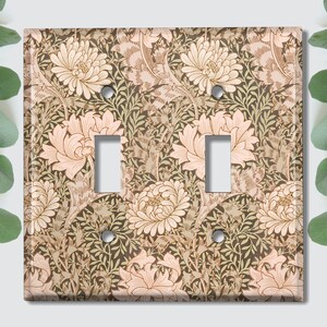 May include: A light switch cover with a floral pattern in shades of brown, green, and pink. The pattern features stylized flowers and leaves.