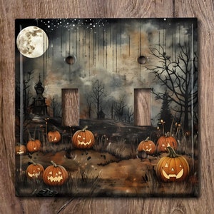 May include: A light switch cover with a spooky Halloween scene. The image features a full moon, a dark forest, and jack-o'-lanterns with glowing faces.