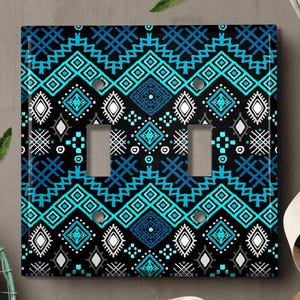 May include: A light switch cover with a geometric pattern in shades of blue, white, and black. The pattern is reminiscent of traditional tribal designs.
