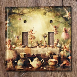 May include: A light switch cover featuring a whimsical illustration of fairies having tea party in a forest setting. The fairies are dressed in pastel colors and have delicate wings. The tea party table is set with teacups, saucers, and a teapot. The background is a lush green forest with a soft, golden light.
