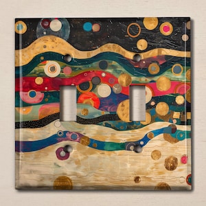 May include: A light switch cover with an abstract design featuring colorful circles, waves, and gold accents on a textured background.