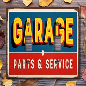 May include: A vintage-style light switch cover with the word "GARAGE" in large yellow letters on a blue background. Below, the words "PARTS & SERVICE" are in white on a red background. The cover has two switch openings.