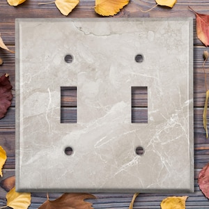 May include: A light gray marble-patterned double light switch cover plate.