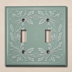 May include: A light blue double light switch cover with an embossed floral design.