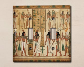 May include: A light switch cover featuring a vintage illustration of Egyptian hieroglyphics and figures in a procession. The figures are depicted in a muted color palette of browns, yellows, and greens.