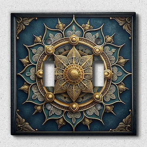 Puede incluir: Una cubierta de interruptor de luz decorativa con un diseño de mandala dorado y azul. El mandala presenta detalles intrincados y un motivo floral central.