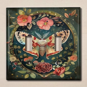 May include: Decorative double light switch cover featuring a large moth with patterned wings, surrounded by flowers and foliage. The color palette includes shades of teal, red, and cream, creating a whimsical, nature-inspired design.