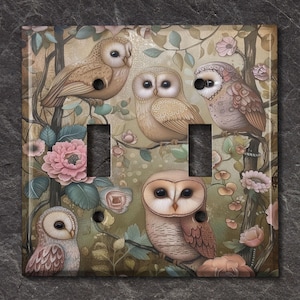 May include: A decorative light switch cover featuring a whimsical design of owls perched on branches amidst flowers. The artwork showcases a soft color palette of beige, brown, and pink, creating a vintage aesthetic. The cover has two switch openings and two screw holes.