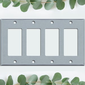 May include: A brushed nickel four-gang wall plate with four rectangular openings for light switches or outlets.