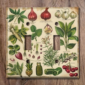 May include: A vintage style light switch cover with a botanical illustration of various plants and herbs. The design features a variety of greens, reds, and yellows. The switch cover is made of durable plastic and is easy to install.