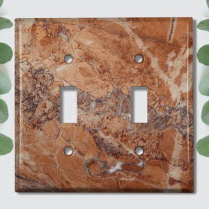 May include: A brown and beige marble light switch cover with two toggle switches.