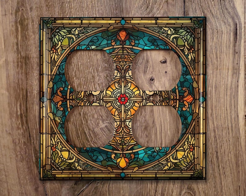 May include: A decorative outlet cover with a stained glass design featuring a circular pattern of blue, green, yellow, and red colors. The design includes intricate floral and geometric motifs.