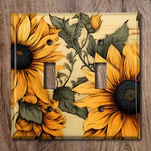 May include: A light switch cover with a floral design featuring sunflowers and green leaves on a light wood background.