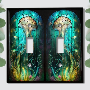 May include: A pair of light switch covers with a stained glass design featuring jellyfish, seaweed, and fish in shades of blue, green, and yellow.