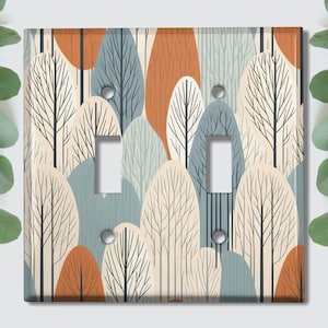 May include: A light switch cover with a stylized pattern of trees in shades of blue, brown, and cream.
