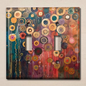 May include: A colorful light switch cover with a pattern of overlapping circles in shades of blue, green, red, yellow, and gold. The circles are arranged in a random pattern and create a visually appealing design.