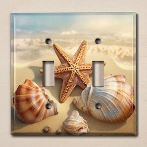 May include: A light brown, beige, and white seashell with a starfish on a sandy beach background. The seashell is on the right side of the image and the starfish is on the left side of the image. The background is a sandy beach with a blue sky and white clouds.