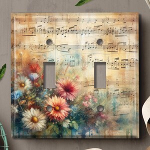 May include: A light switch cover with a vintage floral design and sheet music background. The flowers are painted in shades of pink, white, and blue.