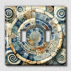 May include: A light switch cover with a decorative design featuring a circular pattern of blue, brown, and white swirls and geometric shapes.