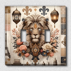 May include: A light switch cover featuring a lion's head with intricate details, surrounded by floral elements and ornate patterns. The design includes a pair of lanterns and a Parisian cityscape.