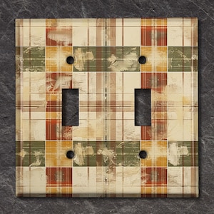May include: A double light switch cover with a plaid pattern in shades of brown, orange, and white.