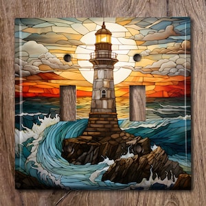May include: A stained glass style light switch cover featuring a lighthouse on a rocky shore with waves crashing against the rocks. The lighthouse is illuminated by a bright yellow sun. The background is a sunset sky with clouds.
