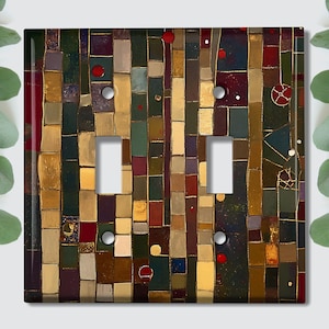 May include: A double light switch cover with a colorful abstract mosaic design. The mosaic features geometric shapes in shades of gold, brown, red, and green.