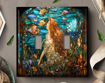 May include: A stained glass light switch cover featuring a mermaid with flowing red hair surrounded by colorful fish and floral designs.