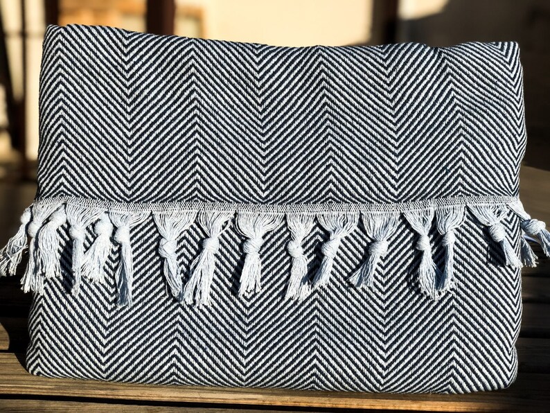 May include: Black and white chevron patterned throw blanket with white fringe tassels.