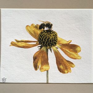 Peut inclure: Une peinture à l'aquarelle d'une fleur jaune avec une abeille dessus. La fleur a un centre brun foncé et l'abeille est noire et brune.