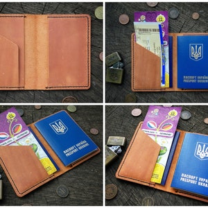 May include: A brown leather passport holder with a blue passport inside. The passport has the Ukrainian coat of arms and the text "PASSPORT UKRAINE" in English and Ukrainian. The holder has a pocket for tickets or other documents.