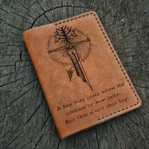 May include: A brown leather passport cover with a tree and sword design and the quote "A day may come when the courage of men fails... But this is not that day!"