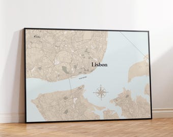 Puede incluir: Impresión enmarcada del mapa de Lisboa, Portugal, con un diseño detallado de las calles en tonos beige sobre un fondo azul claro. El nombre de la ciudad se muestra en una fuente limpia, con una rosa de los vientos y el río Tajo.