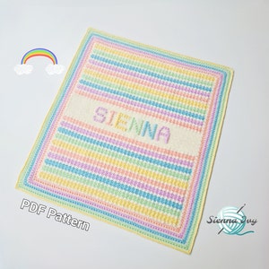 May include: A crochet baby blanket with a rainbow stripe pattern and the name "SIENNA" in white yarn. The blanket has a yellow border and is on a white background.