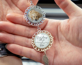 May include: A silver-colored car charm with a photo of a golden retriever dog in a decorative frame. The charm has a second frame with the text "I am always with you Rosie" and a small silver wing charm.