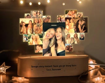May include: A heart-shaped light display featuring a collage of various photographs of people. The light is mounted on a light-colored wooden base with the engraved text: Through every moment, thank you for being there. Love, Aurora.
