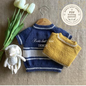 May include: A blue knitted sweater with white horizontal stripes and a white-trimmed collar, paired with a solid mustard yellow knitted sweater. The image includes a small plush rabbit, white tulips, and a logo reading Berta knit store.