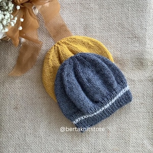 Peut inclure: Deux bonnets en tricot, l'un jaune et l'autre bleu avec une bordure blanche. Les bonnets sont empilés l'un sur l'autre.