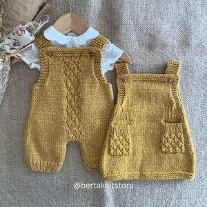 Op de afbeelding: Twee gebreide mosterdgele baby-overalls, een met lange benen en een met een rok-achtige onderkant. Beide hebben zakken en knoopdetails.