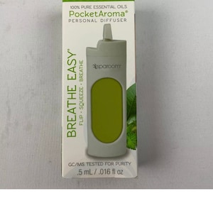 May include: A white and green personal diffuser with the text "PocketAroma®" and "BREATHE EASY" on the packaging. The diffuser is labeled "Flip Squeeze Breathe" and has a green window to see the essential oil inside. The packaging also states "100% Pure Essential Oils" and "GC/MS Tested for Purity .5 mL/.016 fl oz".