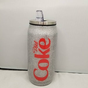 May include: Silver glitter tumbler with a red "Diet Coke" logo and a clear lid with a straw.