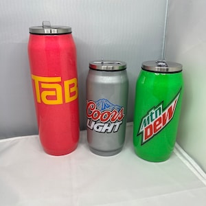 May include: Three stainless steel tumblers with lids. The tumblers are decorated with logos for Tab, Coors Light, and Mountain Dew.