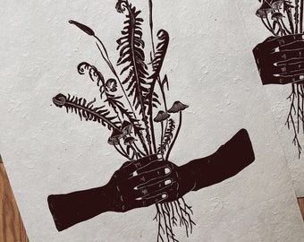 May include: A black and white illustration of a hand holding a bouquet of ferns and mushrooms.