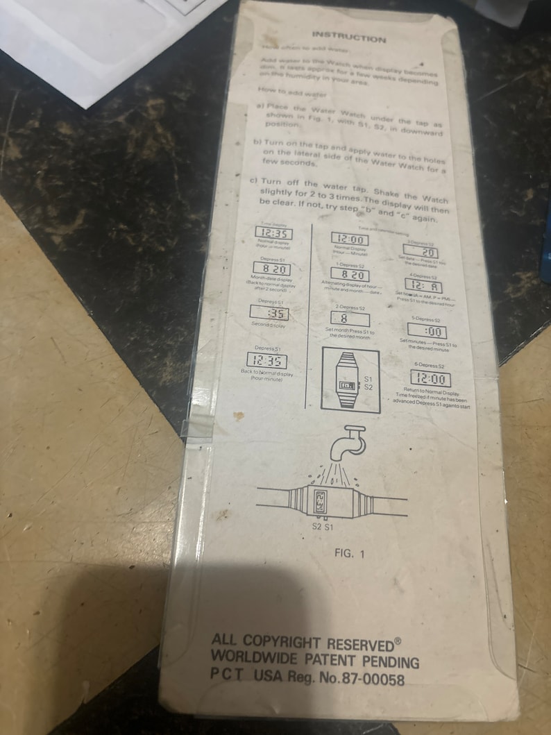 May include: A black and white instruction sheet for a water watch. The instructions show how to set the time and date on the watch. The watch has a black and white display with a white background and black numbers. The watch is shown in a diagram with water flowing over it.